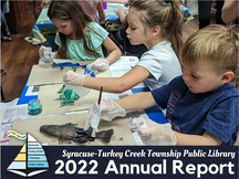 Syracuse-Turkey Creek Township Public Library 2022 Annual Report Cover featuring children doing a craft