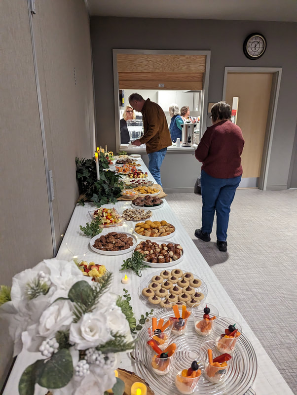 Pictured is the appetizer table, which features a wide range of baked goods, fruit, and vegetables.