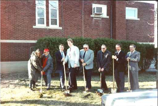A group of people with shovel break ground for the remodel.
