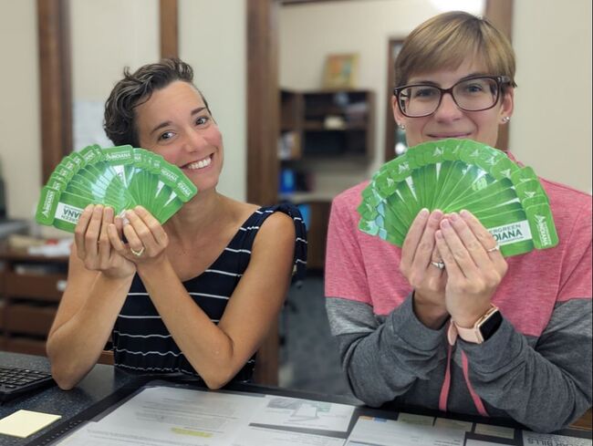 Photo of Michelle Parker and Katie Graham holding Evergreen Indiana cards