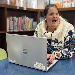 Megan Daumen with a laptop in the children's department