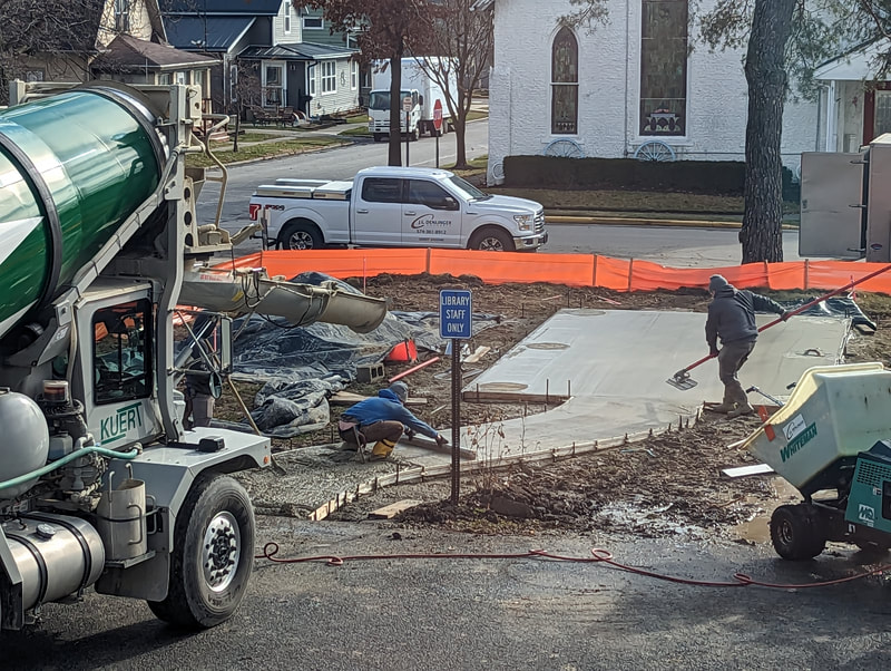 Contractors pour concrete for Community Roots' pavilion's foundation and walkway.