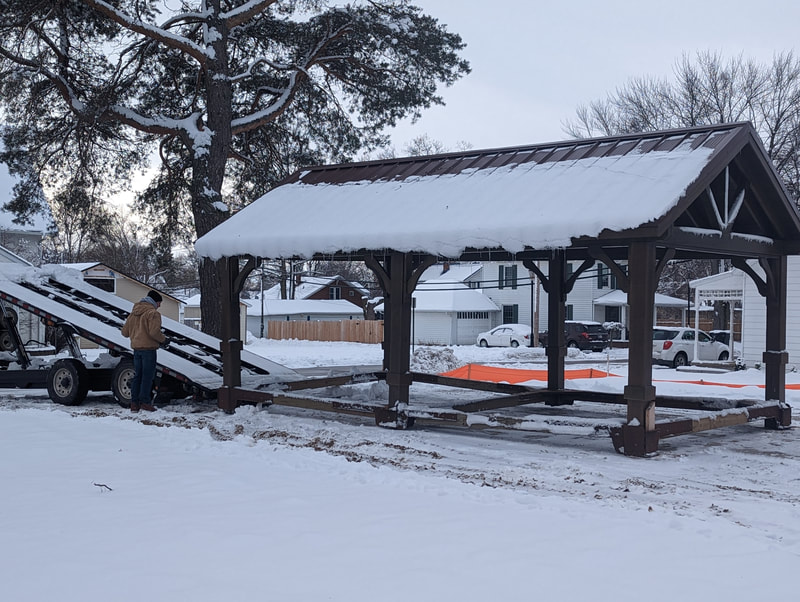 Pavilion slides off trailer into its spot in Community Roots.